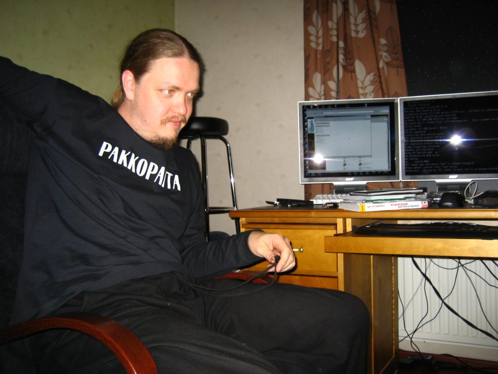 Old picture of a man sitting in front of a computer.