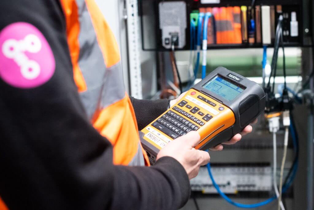 Employee holds implementation device in his hands.