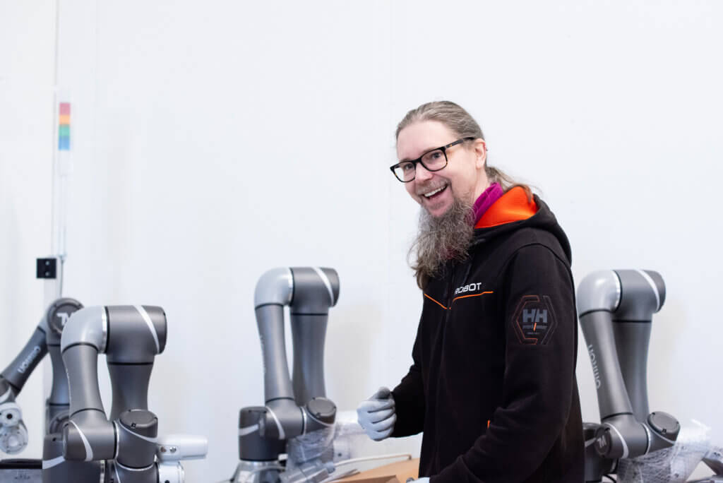 Automaatioinsinöörimme Jani Juntikka hallillamme ottamassa Omronin yhteistyörobotteja esille paketeistaan. Robotiikka saa hänet aina hyvälle tuulelle.