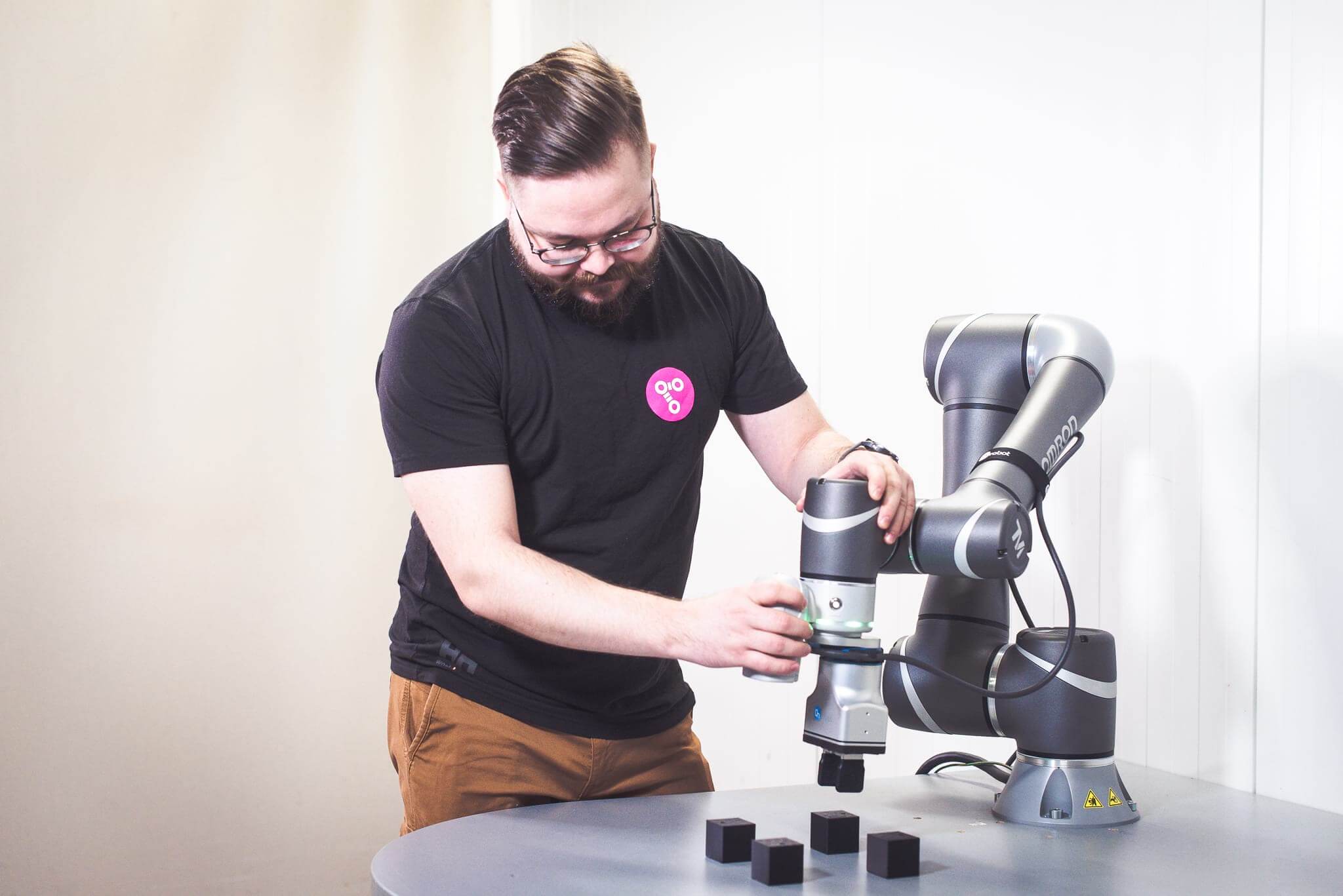 A man working with the Omron cobot.