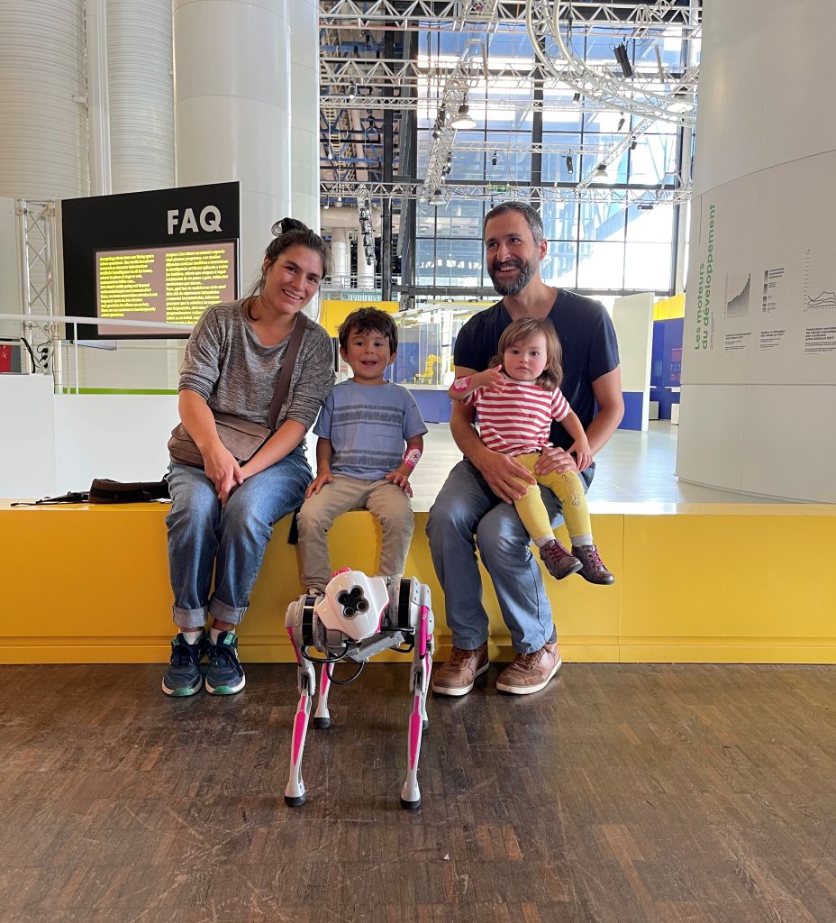 Robot dog poses in front of a family of four.