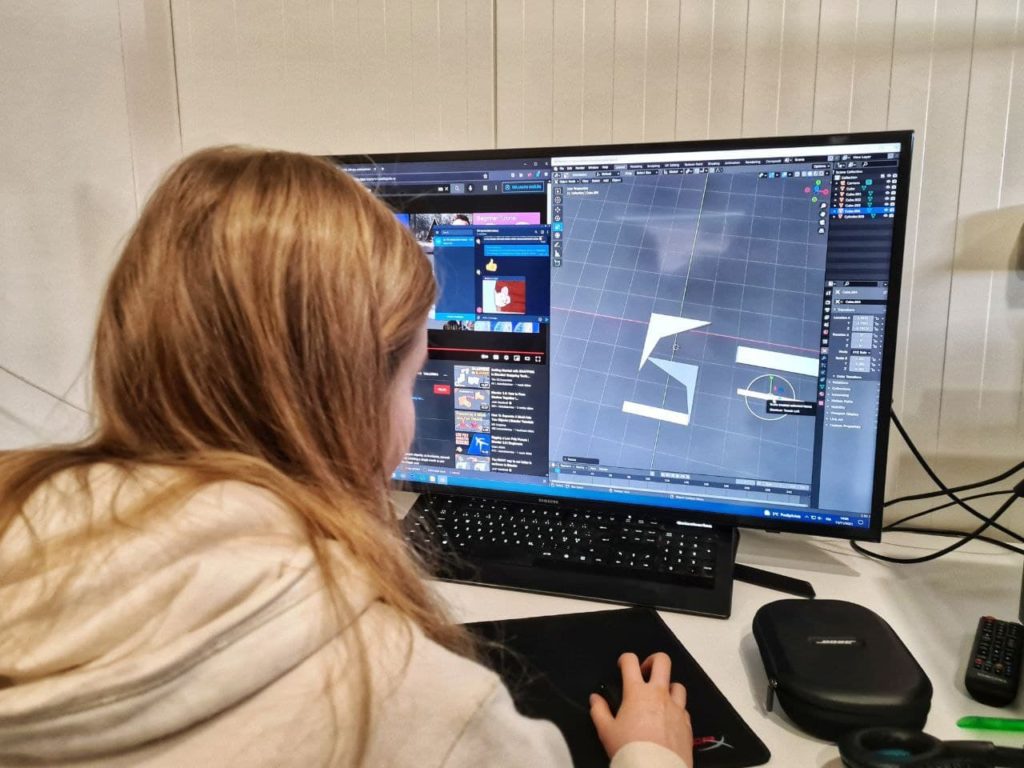 Tyttö istuu koneen äärellä ja harjoittelee käyttämään 3D-mallinnus ohjelmaa
