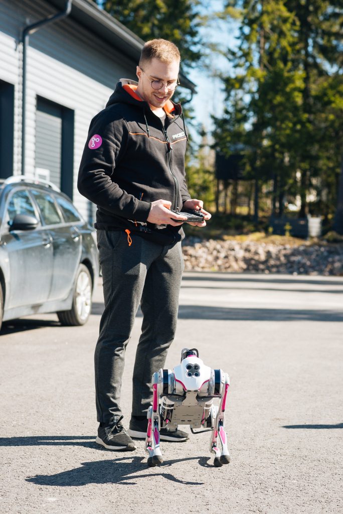 Mies seisoo ulkona robottikoiran kanssa tämän ohjain käsissään - 10 kysytyintä kysymystä robottikoirasta