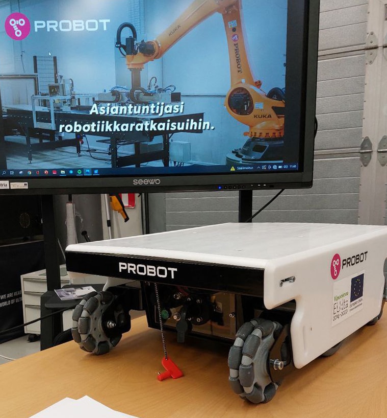 Mobile robot on the table. behind is a screen with a company presentation.